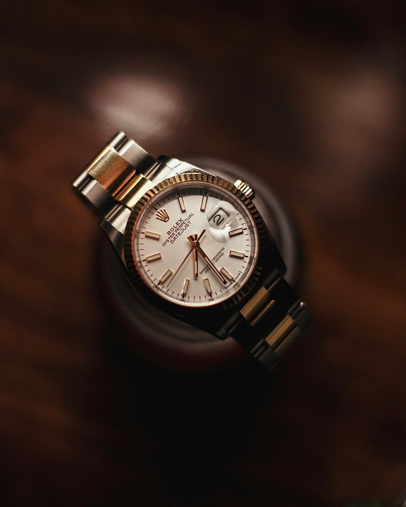 Two-tone watch photographed from above in warm light